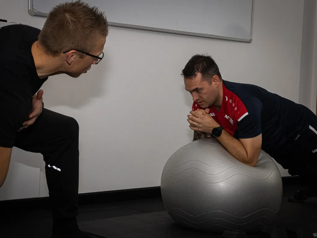 Coach begeleidt een sporter tijdens krachttraining in de studio van Process in Balen